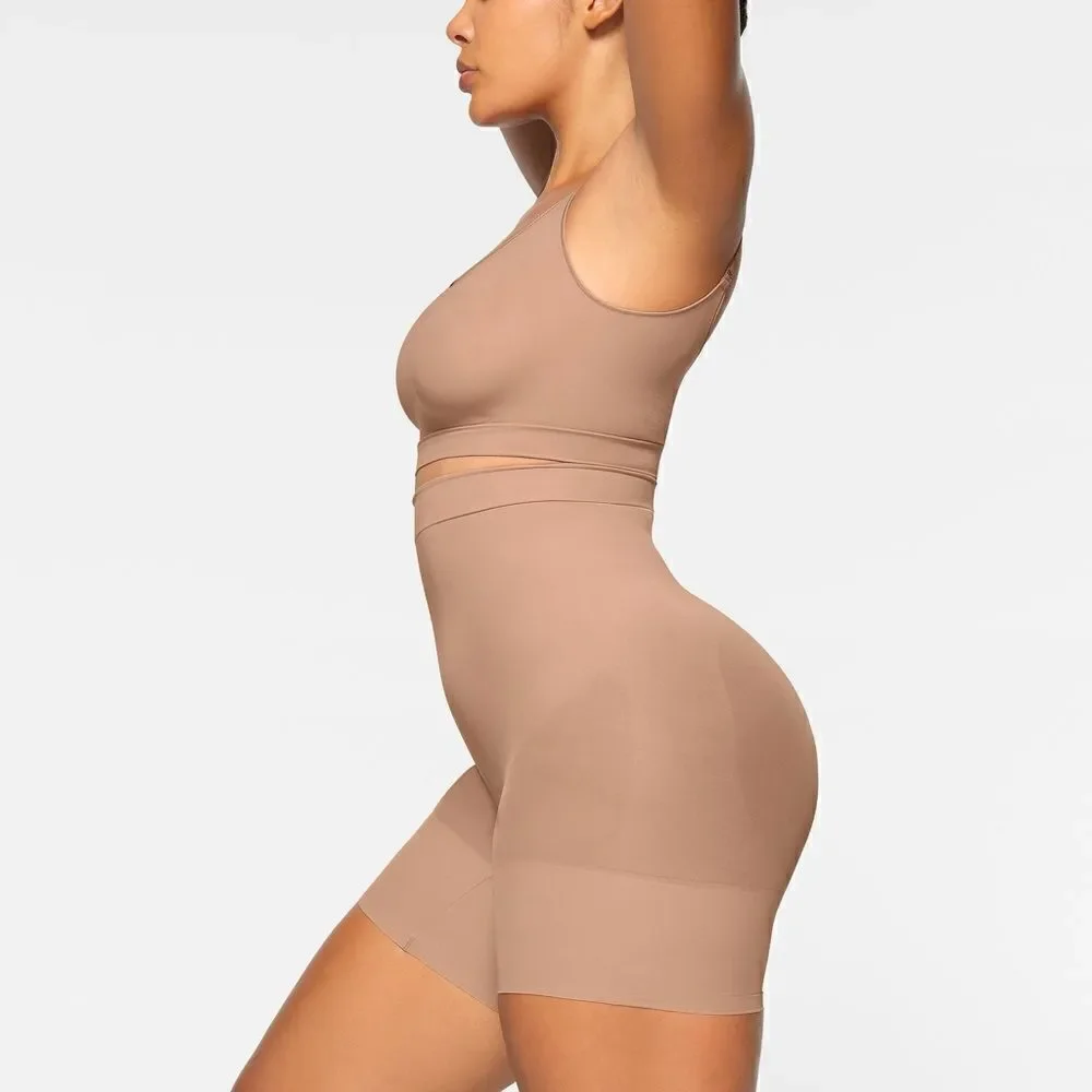 SKIMS high-waisted mid thigh short in color sienna in the size Small